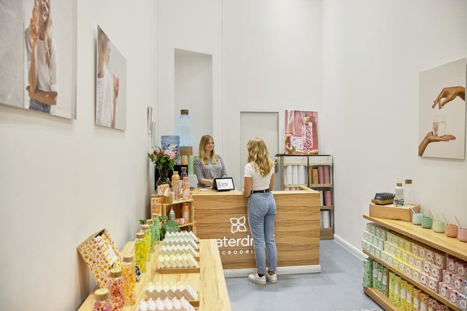A friendly interaction between two women in a stylish Berlin boutique store. Modern decor and products on display.